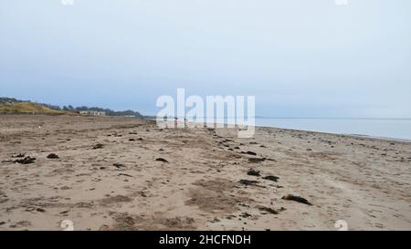 Broughty Ferry Beach, Schottland, an einem bewölkten Tag. Gelber Sand im Vordergrund, blauer Himmel und Meerwasser im Hintergrund. Stockfoto