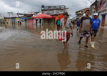 Bahia State, Brasilien. 28th Dez 2021. Am 28. Dezember 2021 laufen Menschen auf einer wasserverlaufenden Straße, während Überschwemmungen durch starke Regenfälle in der Stadt Dario Meira, Bundesstaat Bahia, Brasilien, verursacht wurden. Laut einem Bericht der Zivilschutzbehörden des Bundesstaates Bahia stieg die Zahl der Todesopfer durch schwere Regenfälle, die den nordöstlichen brasilianischen Bundesstaat Bahia heimgesucht haben, am Montag auf 20 an, wobei 358 Menschen verletzt wurden. Nach Angaben des Nationalen Instituts für Meteorologie wird sich die hohe Regenmenge, die das südliche Bahia seit November verwüstet hat, diese Woche fortsetzen und bis in den Januar hinein ausdehnen. Quelle: Xinhua/Alamy Live News Stockfoto