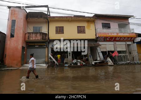 Bahia State, Brasilien. 28th Dez 2021. Am 28. Dezember 2021 geht eine Frau auf einer mit Wasser bemundeten Straße während der Überschwemmungen, die durch starke Regenfälle in der Stadt Dario Meira, Bundesstaat Bahia, Brasilien, verursacht wurden. Laut einem Bericht der Zivilschutzbehörden des Bundesstaates Bahia stieg die Zahl der Todesopfer durch schwere Regenfälle, die den nordöstlichen brasilianischen Bundesstaat Bahia heimgesucht haben, am Montag auf 20 an, wobei 358 Menschen verletzt wurden. Nach Angaben des Nationalen Instituts für Meteorologie wird sich die hohe Regenmenge, die das südliche Bahia seit November verwüstet hat, diese Woche fortsetzen und bis in den Januar hinein ausdehnen. Quelle: Xinhua/Alamy Live News Stockfoto