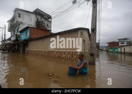 Bahia State, Brasilien. 28th Dez 2021. Am 28. Dezember 2021 durchläuft ein Mann eine mit Wasser bemundete Straße während einer Überschwemmung, die durch heftige Regenfälle in der Stadt Dario Meira, Bundesstaat Bahia, Brasilien, verursacht wurde. Laut einem Bericht der Zivilschutzbehörden des Bundesstaates Bahia stieg die Zahl der Todesopfer durch schwere Regenfälle, die den nordöstlichen brasilianischen Bundesstaat Bahia heimgesucht haben, am Montag auf 20 an, wobei 358 Menschen verletzt wurden. Nach Angaben des Nationalen Instituts für Meteorologie wird sich die hohe Regenmenge, die das südliche Bahia seit November verwüstet hat, diese Woche fortsetzen und bis in den Januar hinein ausdehnen. Quelle: Xinhua/Alamy Live News Stockfoto