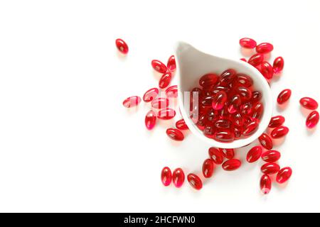 Krillöl-Gelatine-Kapseln in weißer Tasse auf weißem Hintergrund.Omega-Fettsäuren.gesunde Ernährung und Nahrungsergänzungsmittel Stockfoto