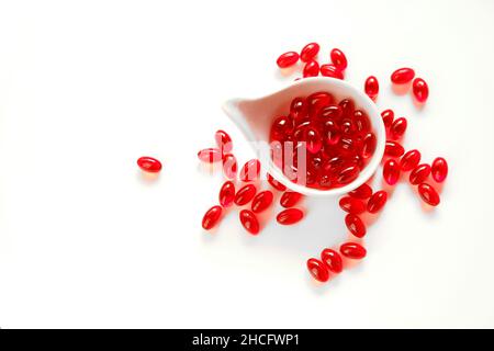 Krillöl-Gelatine-Kapseln in weißer Tasse auf weißem Hintergrund.Omega-Fettsäuren.gesunde Ernährung und Nahrungsergänzungsmittel Stockfoto