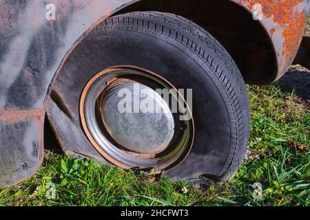 Reifenpannen bei altem, verrostetem Fahrzeug Stockfoto
