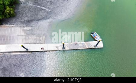 Werfen eines Werfnetzes vom Anleger an der Bootsrampe von Conway Beach, Whitsunday Region, Queensland, Australien Stockfoto