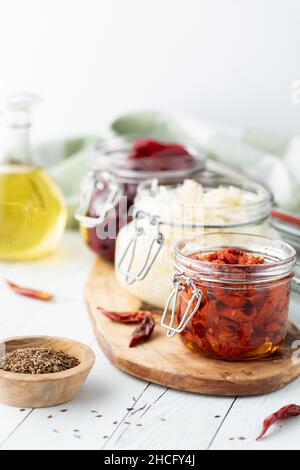 Gläser eingelegter Konfitüren, einschließlich Rüben, Sauerkraut und Tomaten. Stockfoto