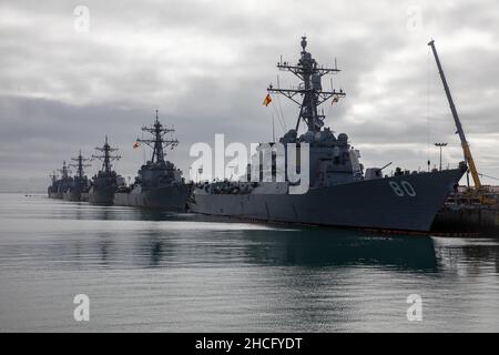 MARINESTÜTZPUNKT ROTA, Spanien (Dez 27, 2021) der Arleigh Burke-Klasse Lenkflugkörper-Zerstörer USS Roosevelt (DDG 80), von vorne, der Arleigh Burke-Klasse Lenkraketen-Zerstörer USS Porter (DDG 78), der Arleigh Burke-Klasse Lenkraketen-Zerstörer USS Arleigh Burke (DDG 51) und der Arleigh Burke-Klasse Lenkraketen-Zerstörer USS Ross (DDG 71), Marinestation Rota, Spanien 27. Dezember 2021. Roosevelt, der im spanischen Rota stationiert ist, befindet sich auf seiner dritten Patrouille im Einsatzgebiet der Sechsten US-Flotte zur Unterstützung regionaler Verbündete und Partner sowie der nationalen Sicherheitsinteressen der USA in EUR Stockfoto