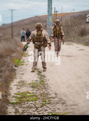 US Marine Corps Staff Sgt. Sebastian Torres (links) und Sgt. Tyler Jones, Techniker für die Entsorgung von Sprengkörpern bei 1st Explosive Ordnance Disposal Company, 7th Engineer Support Bataillon, 1st Marine Logistics Group, während des Szenariotrainings auf Camp Pendleton California, 13. Dezember 2021, nach Bomben fegen. In dieser Schulung werden EOD-Techniker mit den Werkzeugen und Techniken vertraut gemacht, die zum Auffinden und zur sicheren Verwendung improvisierter explosiver Geräte verwendet werden. (USA Marine Corps Foto von CPL. William Redding) Stockfoto