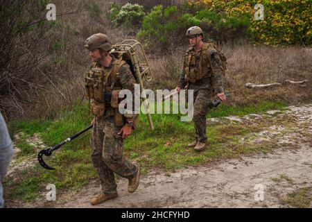 US Marine Corps Staff Sgt. Paul Butcher, links, und Sgt. Dan Metz, Techniker für die Entsorgung von Sprengkörpern bei 1st Explosive Ordnance Disposal Company, 7th Engineer Support Battalion, 1st Marine Logistics Group, führt eine Szenariotraining auf Camp Pendleton California durch, 13. Dezember 2021. In dieser Schulung werden EOD-Techniker mit den Werkzeugen und Techniken vertraut gemacht, die zum Auffinden und zur sicheren Wiedergabe improvisierter Sprengkörper verwendet werden. (USA Marine Corps Foto von CPL. William Redding) Stockfoto