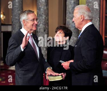 Der Mehrheitsführer des US-Senats, Harry Reid (Demokrat von Nevada), hebt seine rechte Hand während des Fotos der Nachstellung seiner Vereidigung in der Alten Senatskammer im US-Kapitol in Washington, DC am Mittwoch, dem 5. Januar 2011. Seine Frau, Landra, ist im Zentrum und US-Vizepräsident Joe Biden ist rechts.Kredit: Ron Sachs/CNP.(EINSCHRÄNKUNG: KEINE New York oder New Jersey Zeitungen oder Zeitungen in einem Umkreis von 75 Meilen von New York City) Stockfoto