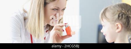 Der Arzt des Pneumologen hält einen Hormoninhalator vor dem kleinen Mädchen in der Klinik. Stockfoto