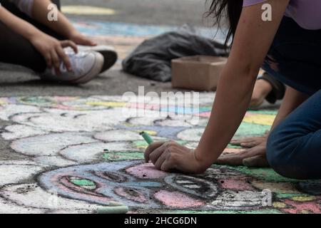 Die Kinder bereiten die Straßen mit kalkbemalten Kunstwerken vor, die Tage vor der Begnagung des „Carnaval de Negros y Blancos 2022“, der vom 2nd. Januar bis zum 7th. Januar in Pasto, Nariño - Kolumbien, am 28. Dezember als immaterielles Kulturerbe der Menschheit gilt, 2021. Stockfoto