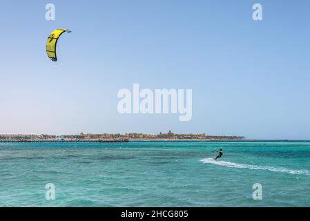 Hurghada, Ägypten - 02. Juni 2021: Kitesurfmann mit Kite in Himmel an Bord in Wellen auf dem Meer in Makadi Bay, die eine von Ägypten schönen Roten Meer Ri Stockfoto