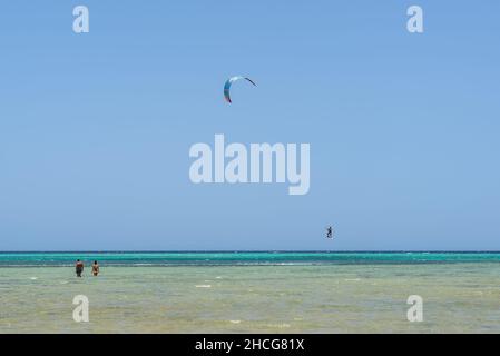 Hurghada, Ägypten - 02. Juni 2021: Silhouette eines springenden Kitesurfers in der Makadi Bay, einer von Ägyptens schönen Riviera am Roten Meer. Kiteboarding-Sport. Stockfoto