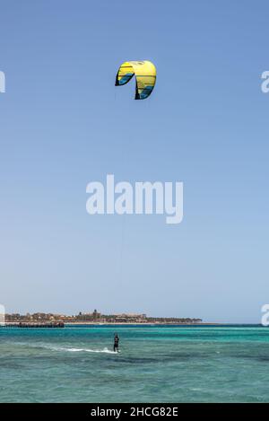 Hurghada, Ägypten - 02. Juni 2021: Kitesurfmann mit Kite in Himmel an Bord in Wellen auf dem Meer in Makadi Bay, die eine von Ägypten schönen Roten Meer Ri Stockfoto