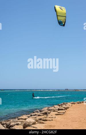 Hurghada, Ägypten - 02. Juni 2021: Kitesurfmann mit Kite in Himmel an Bord in Wellen auf dem Meer in Makadi Bay, die eine von Ägypten schönen Roten Meer Ri Stockfoto