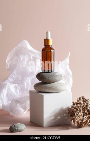 Serumessenz auf Podestbühne auf beigem Hintergrund mit steinigem, zerknittertem Papier. Hautpflege Kosmetik. Produktpräsentationskonzept Stockfoto