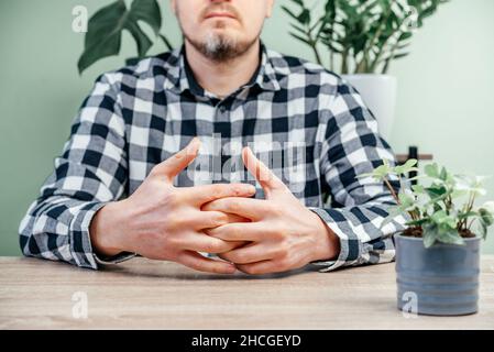 Ein Mann, der Schmerzen in der Hand, rheumatoide Arthritis und Gelenkentzündungskonzept spürt Stockfoto