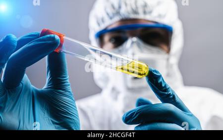 Ärztin oder Wissenschaftlerin hält einen erfundenen gelben Impfstoff gegen Covid 19 oder Coronavirus Stockfoto