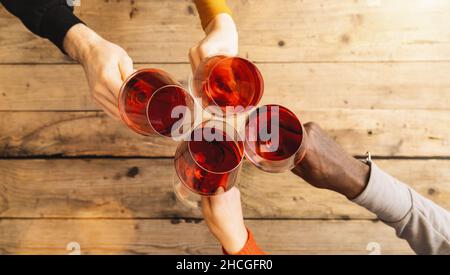 Freunde toasten Rotweinglas und haben Spaß beim Weinanfeuern - Junge Leute genießen Zeit zusammen in einer Weinbar - Jugend und Freunde Stockfoto
