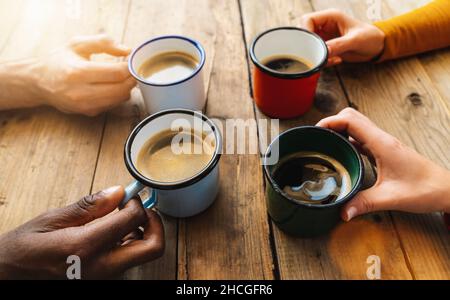 Freunde Gruppe trinkt Cappuccino bei Kaffee in einer Bar Restaurant - Menschen Hände jubeln und toasten - Gesellschaftliches Zusammentreffen Konzept mit weißen und schwarzen m Stockfoto