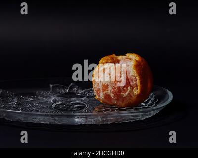 Nahaufnahme einer halbgeschälten Mandarinorange auf schwarzem Hintergrund Stockfoto