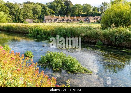 Abends fällt Licht auf die Arlington Row, Weberhütten aus dem späten 14th. Jahrhundert neben dem River Coln im Cotswold-Dorf Bibury, Gloucestershire, Großbritannien Stockfoto