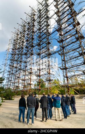 Duga Radar mit einer Gruppe von Touristen und Reiseleiter. Vertikales Foto.Tschernobyl-Tour. Pripyat.08.0.2019 Stockfoto