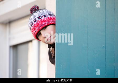 Ein kleiner Junge schaut aus der Tür. Stockfoto