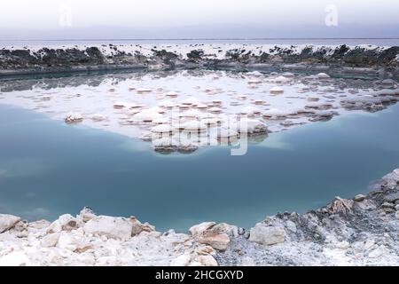 Schönes und farbenfrohes natürliches Salzreservoir nach Regen während des bewölkten Herbsttages am Tuzsee in zentralanatolien, Türkei. Stockfoto