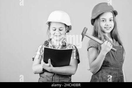 Vorarbeiter-Inspektor. Reparatur. Glückliche Kinder. Zukünftige Karriere. Kleine Kinder im Helm mit Tablet und Hammer. Arbeitstag. 1. Mai. Kleine Mädchen reparieren Stockfoto