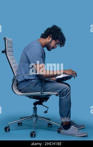 Fokussierter indischer Mann, der seine Tagebucheinträge durchgeht Stockfoto