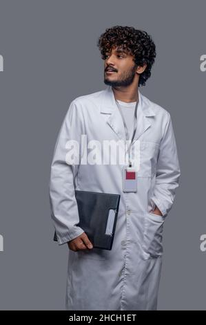 Arzt mit einem Aktenordner in der Hand, der wegschaut Stockfoto