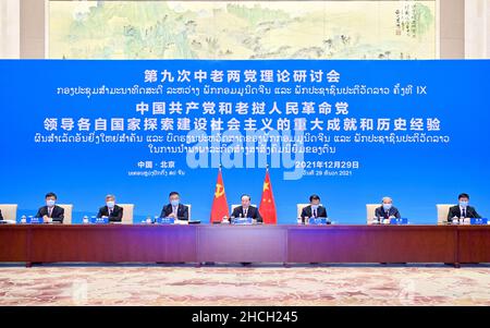 (211229) -- PEKING, 29. Dezember 2021 (Xinhua) -- Huang Kunming, Mitglied des Politbüros des Zentralkomitees der Kommunistischen Partei Chinas (KPCh), Mitglied des Sekretariats des Zentralkomitees der Kommunistischen Partei Chinas (KPCh) und Leiter der Öffentlichkeitsarbeit des Zentralkomitees der KPCh, Nimmt an einem Theorieseminar via Video-Link in Peking, der Hauptstadt von China, Teil, 29. Dezember 2021. Die CPC und die Laos People's Revolutionary Party (LPRP) hielten am Mittwoch ihr neuntes Theorieseminar via Video-Link ab. Im Mittelpunkt des Seminars standen die wichtigsten Errungenschaften und historischen Erfahrungen der beiden Parteien, die ihre jeweiligen Partner leiten Stockfoto