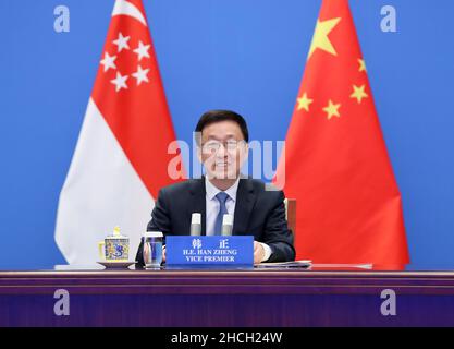 (211229) -- PEKING, 29. Dezember 2021 (Xinhua) -- Der chinesische Vizepremierminister Han Zheng, ebenfalls Mitglied des Ständigen Ausschusses des Politbüros des Zentralkomitees der Kommunistischen Partei Chinas, trifft sich mit dem stellvertretenden Premierminister Heng Swee Keat aus Singapur via Videolink in Peking, der Hauptstadt Chinas, am 29. Dezember 2021. Han Zheng und Heng Swee Keat führten gemeinsam den Vorsitz beim Treffen des Gemeinsamen Rates für bilaterale Zusammenarbeit 17th zwischen China und Singapur, beim Treffen des Gemeinsamen Lenkungsrats des China-Singapur-Industrieparks Suzhou (13th), beim Treffen des China-Singapur-Ökologische-Stadt-JSC 5th in Tianjin und beim Treffen China-Singapur (C) 22nd Stockfoto