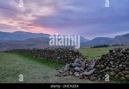 Gebrochene Steinmauer mit Blick auf St. John's im Valle, in der Nähe von Keswick, Lake District, Cumbria. Stockfoto