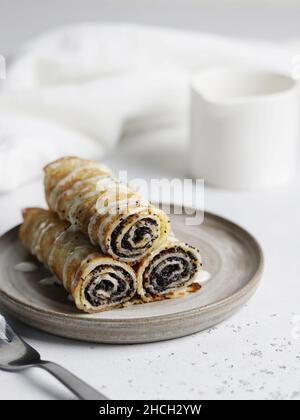 Mohn Crepes (Blinis). Pfannkuchen mit Mohngefühl für maslenitsa auf weißem strukturiertem Hintergrund Stockfoto