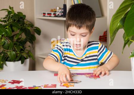 Ein Vorschulkinder spielt Puzzles, stellt ein Bild zusammen Stockfoto