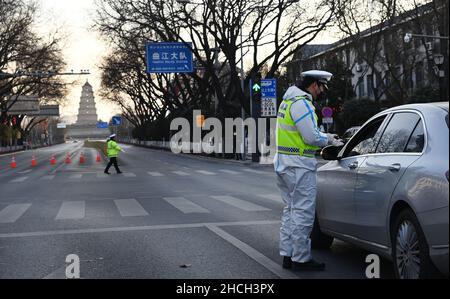 (211229) -- XI'AN, 29. Dezember 2021 (Xinhua) -- Polizisten arbeiten auf einer Straße in Xi'an, der Hauptstadt der nordwestlichen chinesischen Provinz Shaanxi, am 29. Dezember 2021. Die Behörden in Xi'an haben ab Montag die Maßnahmen zur Bekämpfung und Prävention von Epidemien verbessert und alle Bewohner aufgefordert, sich in Innenräumen aufzuhalten und Versammlungen zu unterlassen, außer bei Nukleinsäuretests. (Xinhua/Tao Ming) Stockfoto