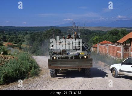 - NATO-Intervention im Kosovo, gepanzerte Fahrzeuge der spanischen Armee patrouillieren auf einer Straße in der Nähe der Stadt Istok (Juli 2000) - Intervento NATO in Kossovo, veicoli blindati dell'esercito spagnolo pattugliano una strada vicino alla città di Istok (Luglio 2000) Stockfoto