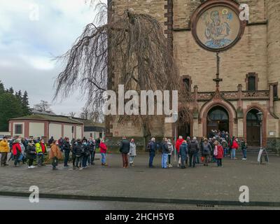 Neuwied, Deutschland - 15. Dezember 2021: Lange Schlange vor einer Kirche, die auf eine Auffrischungsimpfung gegen den Corona-Virus wartet Stockfoto