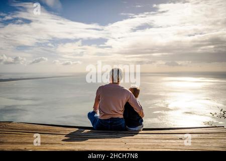 Mutter und 3 Jahre alter Sohn umarmen sich gegenseitig und genießen die wunderschöne Aussicht auf das Meer, Portugal Stockfoto