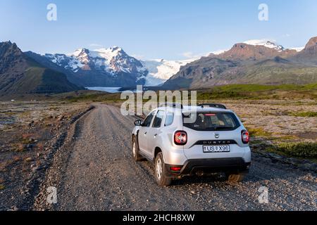 Auto auf Schotterstraße, Vatnajoekull Gletscher, Berge und weite Landschaft dahinter, Ring Road, Island Stockfoto