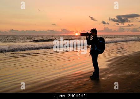 Fotograf, der bei Sonnenuntergang am Meer fotografiert, Gran Canaria, Kanarische Inseln, Spanien Stockfoto