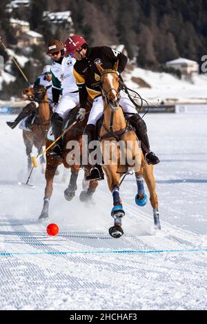 Valentin Novillo Astrada (schwarz) vom Team Badrutt's Palace Hotel verfolgt von Santiago Marambio (weiß) vom Team Aserbaidschan Land of Fire, 36th Snow Polo Stockfoto