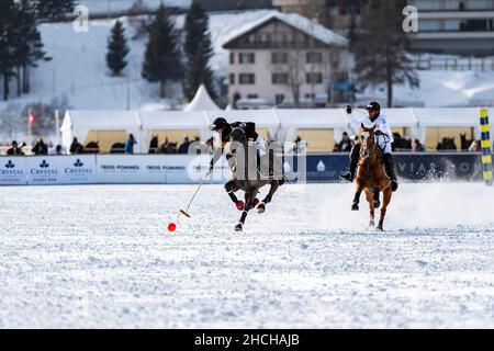 NIC Roldan (schwarz) vom Team Badrutt's Palace Hotel führt den Ball an, verfolgt von Adrian Laplacette jr. (Weiß) vom Team Maserati, Snow Polo World Cup 36th Stockfoto