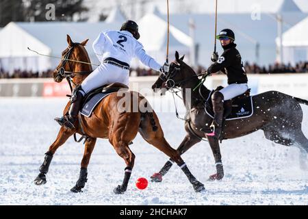 Valentin Novillo Astrada (weiß) vom Team Maserati kämpft gegen Nic Roldan (schwarz) vom Team Badrutt's Palace Hotel um den Ball, den Snow Polo World Cup 36th Stockfoto