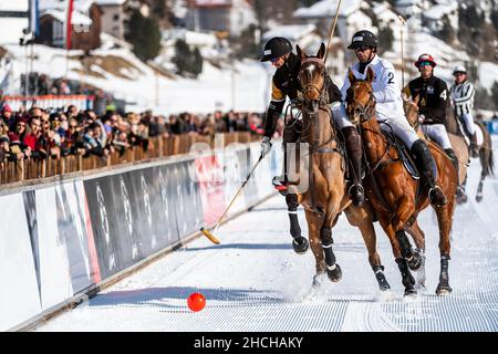 NIC Roldan (schwarz) vom Team Badrutt's Palace Hotel und Valentin Novillo Astrada (weiß) kämpfen auf der Bahn um den Ball, 36th Snow Polo World Cup St. Stockfoto