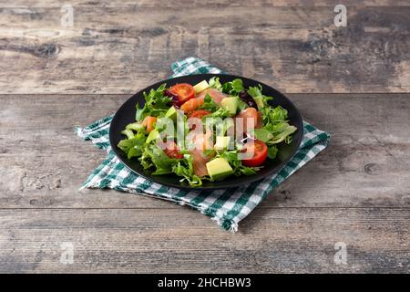 Lachs- und Avocado-Salat auf rustikalem Holztisch Stockfoto