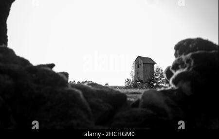 Graustufenaufnahme einer alten verlassenen Windmühle Stockfoto