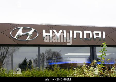 Logo und Name des Autounternehmens Hyundai über dem Eingang eines Autohauses. Stockfoto